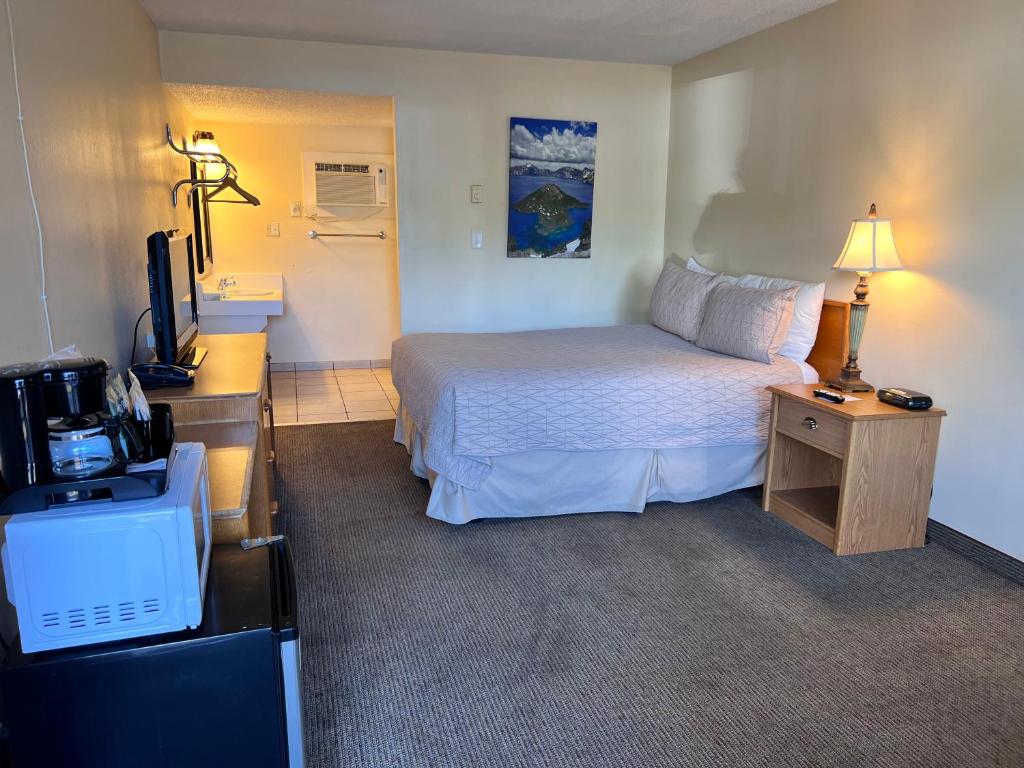 a hotel room with a bed and a television at Timbers INN and Suites in Ashland