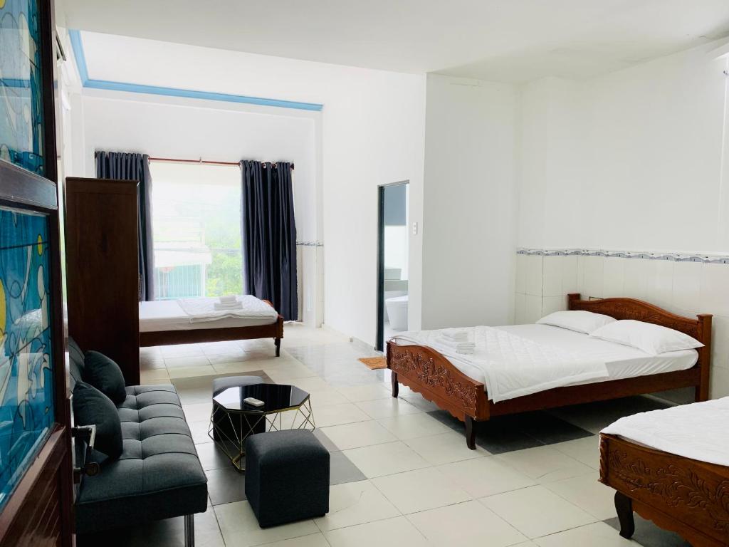 HomeStay KV2 في Bình Thủy: غرفة معيشة بها سريرين وأريكة