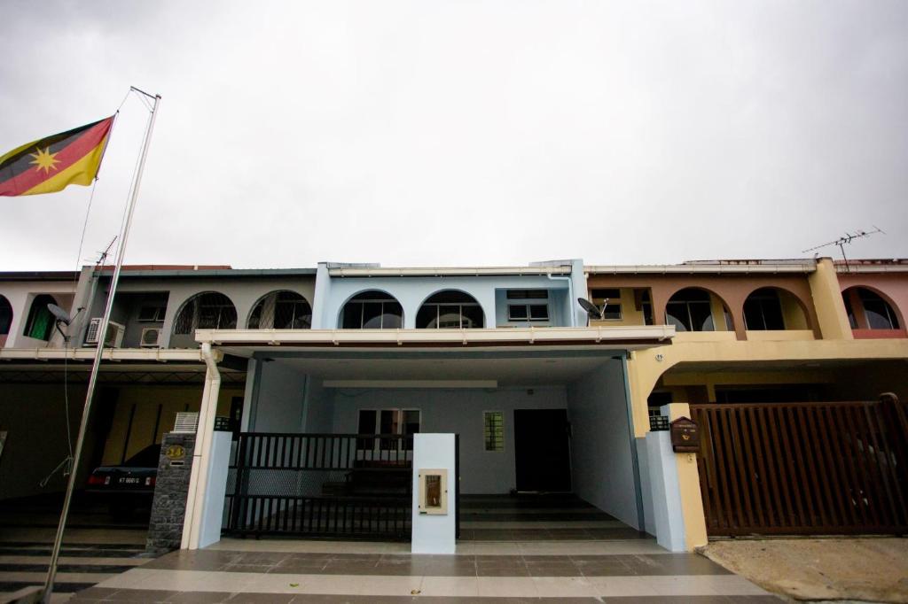 un edificio con una bandiera che batte di fronte ad esso di Hom2rex Kuching Homestay Taman Timberland a Kuching