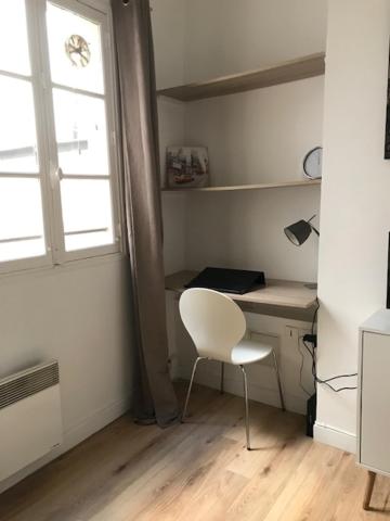 a room with a desk and a chair and a window at Studio Mezzanine N Dame in Versailles