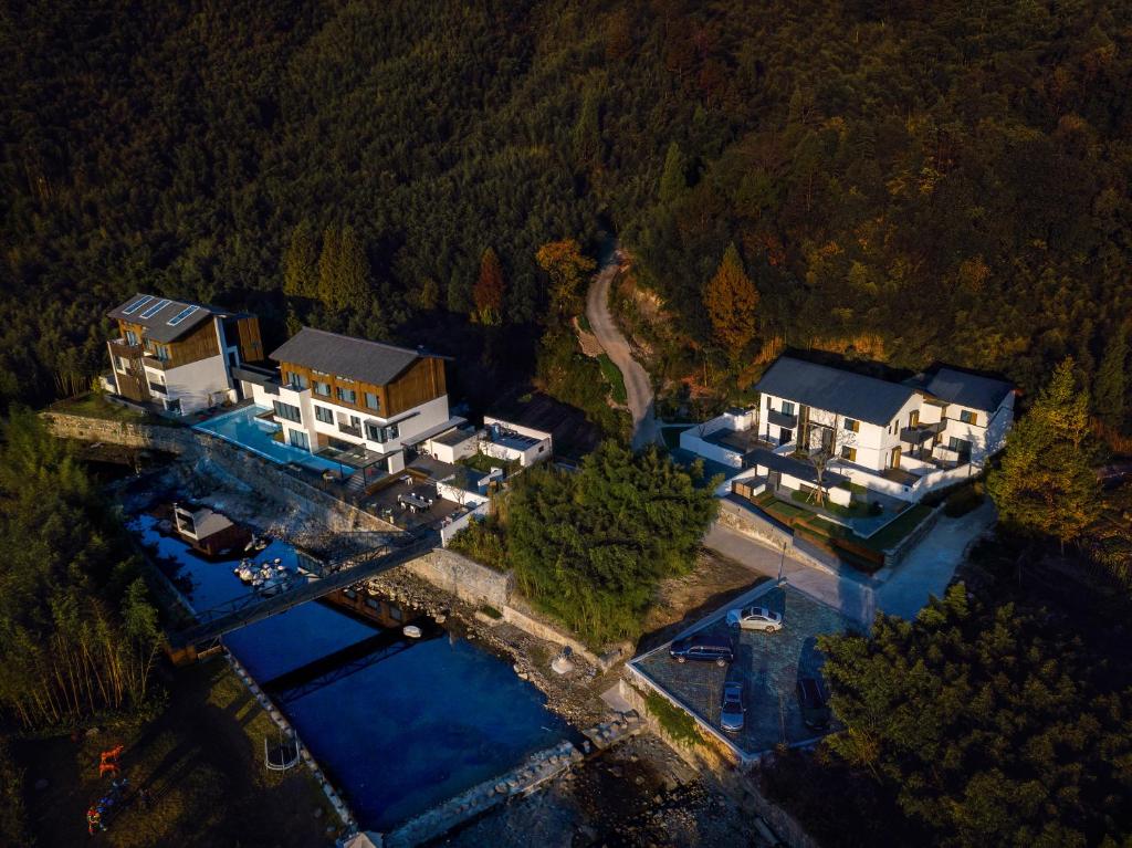 eine Luftansicht eines großen Hauses auf einem See in der Unterkunft Creek Moganshan Design B&B in Deqing