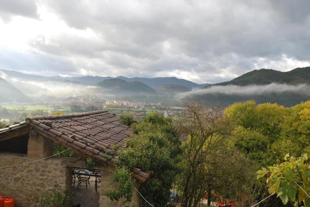 un techo de una casa con montañas en el fondo en Casa de colònies La Cadamont, en Sant Joan les Fonts