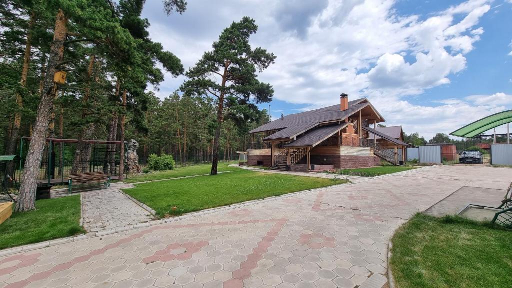 ein Haus mit einem steinernen Gehweg vor einem Haus in der Unterkunft Osobnyak in Schtschutschinsk