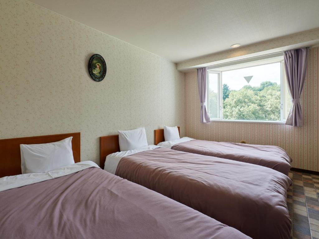 Postel nebo postele na pokoji v ubytování Asama Kogen Hotel