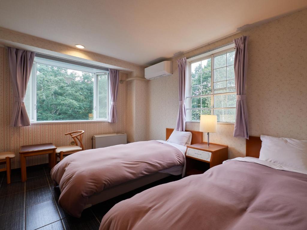 Postel nebo postele na pokoji v ubytování Asama Kogen Hotel