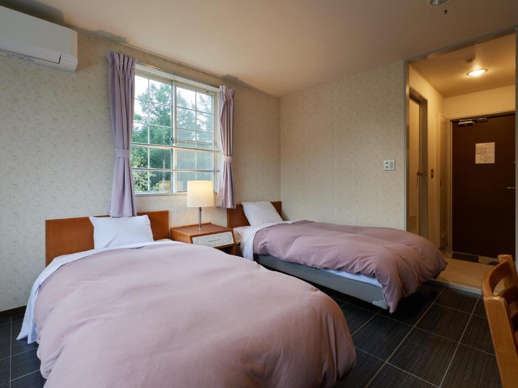 Postel nebo postele na pokoji v ubytování Asama Kogen Hotel