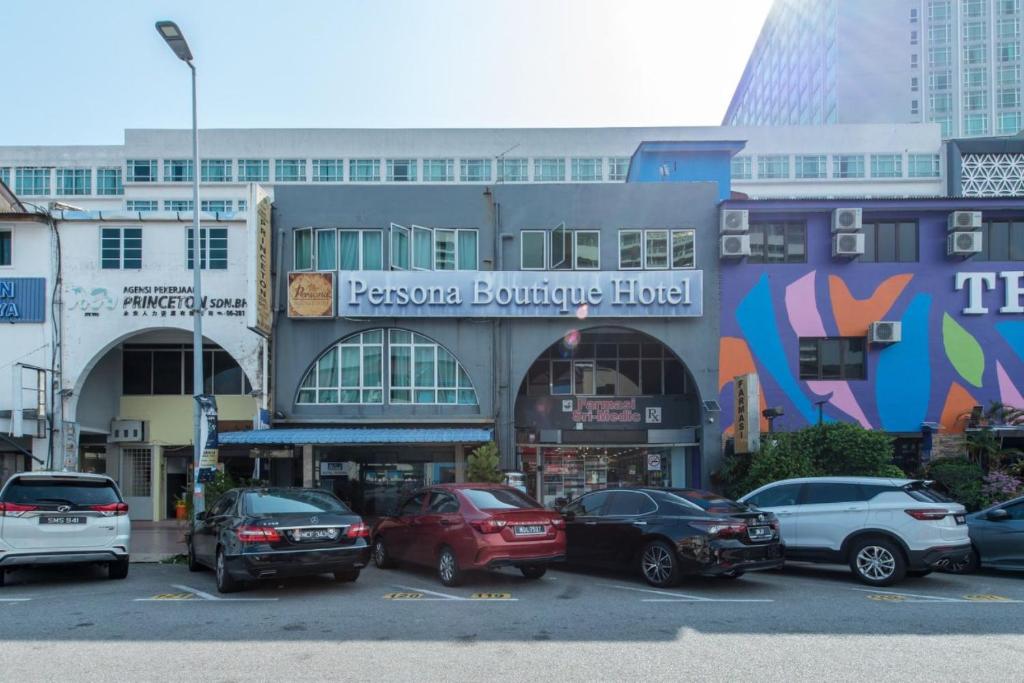 a parking lot with cars parked in front of a building at Persona Boutique Hotel in Melaka