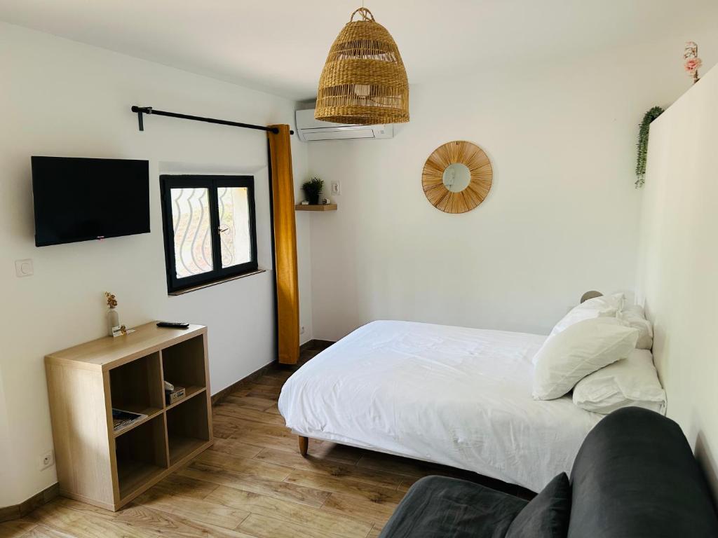 a bedroom with a bed and a tv on the wall at Le Cabanon in Collobrières