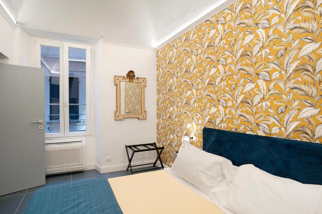 a bedroom with a bed and a wall with a wallpaper at Loft 42 in Alassio