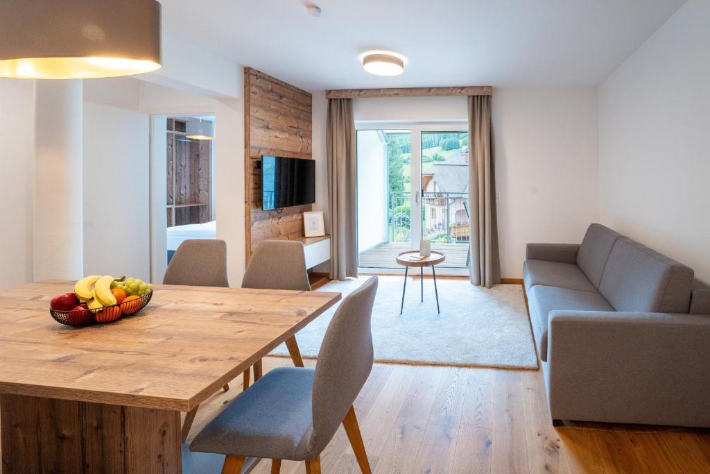 a living room with a wooden table with a bowl of fruit at Apartment Ski&Nature "Fanningberg" in Mauterndorf