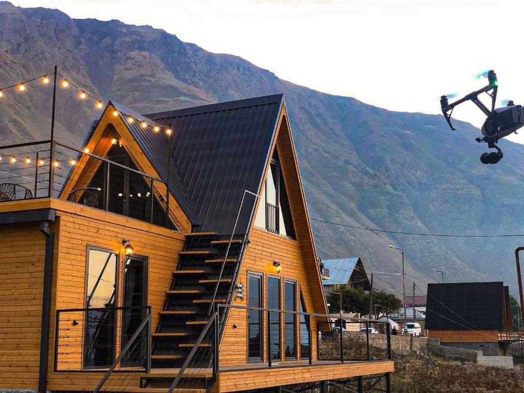 a small wooden house with a black roof at Magic Hut_Kazbegi in Stepantsminda