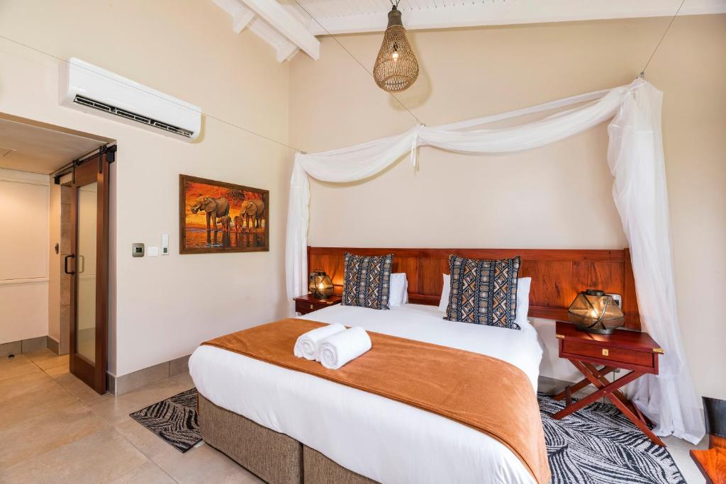 a bedroom with a large white bed in a room at Hwange Safari Lodge in Dete