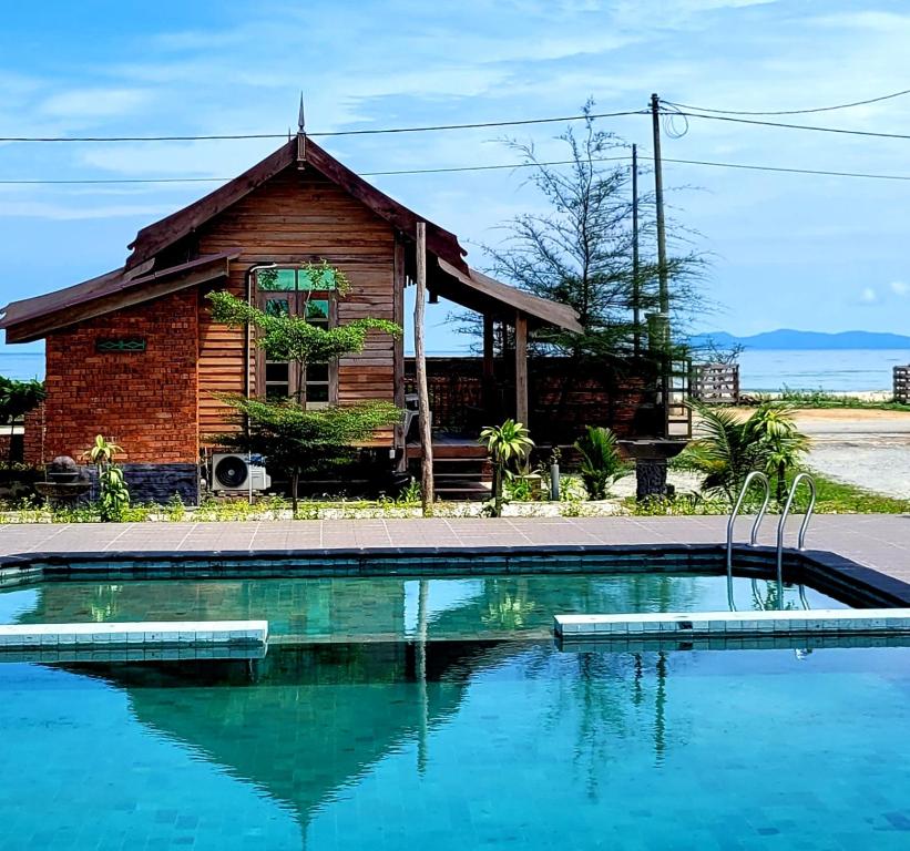 a house with a swimming pool in front of a house at PULANG RESORT in Setiu