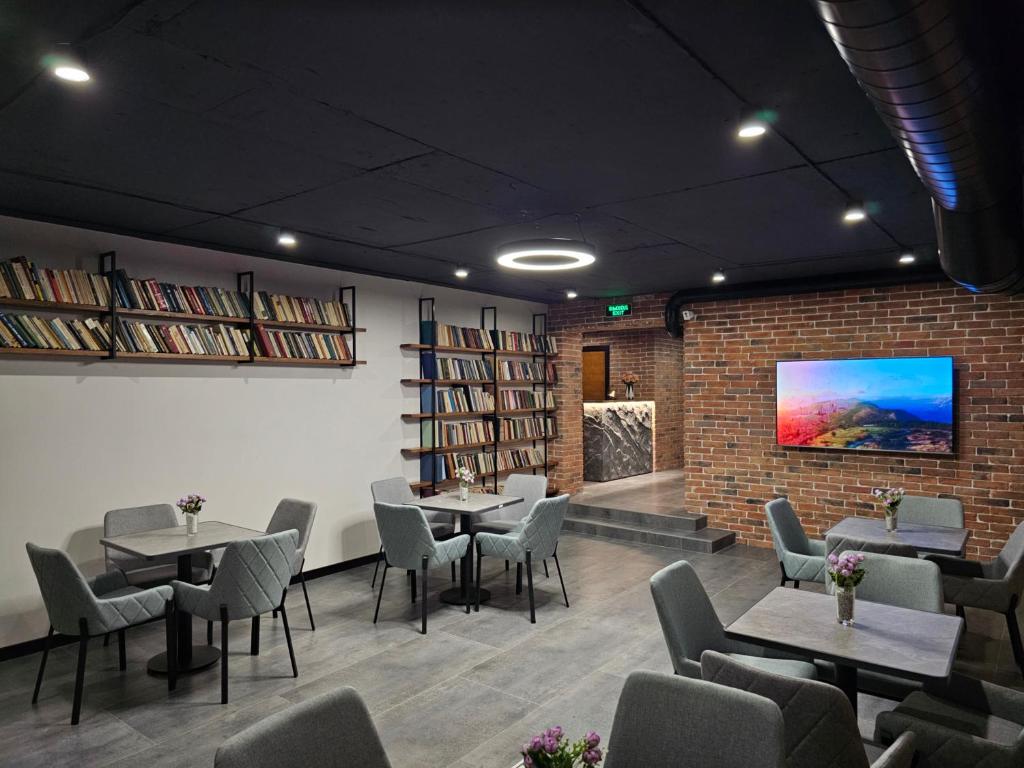 un restaurant avec des tables et des chaises et un mur en briques dans l'établissement Orion Hostel, à Erevan