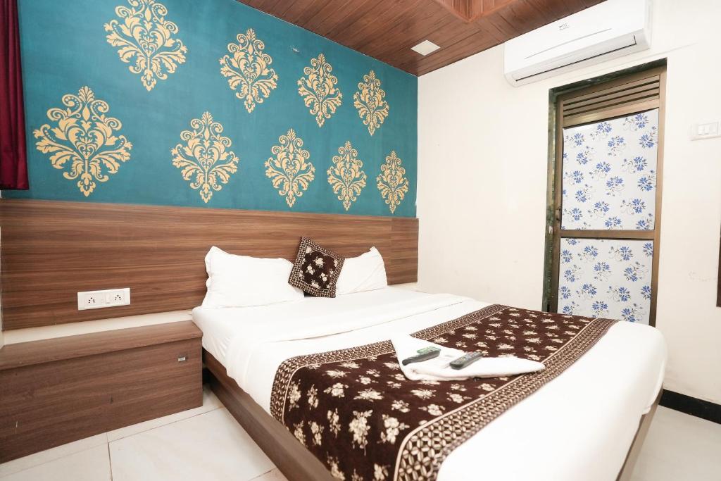 1 dormitorio con 2 camas y pared azul en Hotel Mumbai Residency, en Bombay
