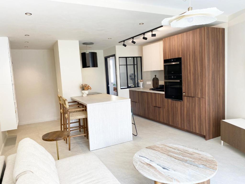 a kitchen and living room with a table and chairs at Le petit Berriat - Grenoble centre in Grenoble