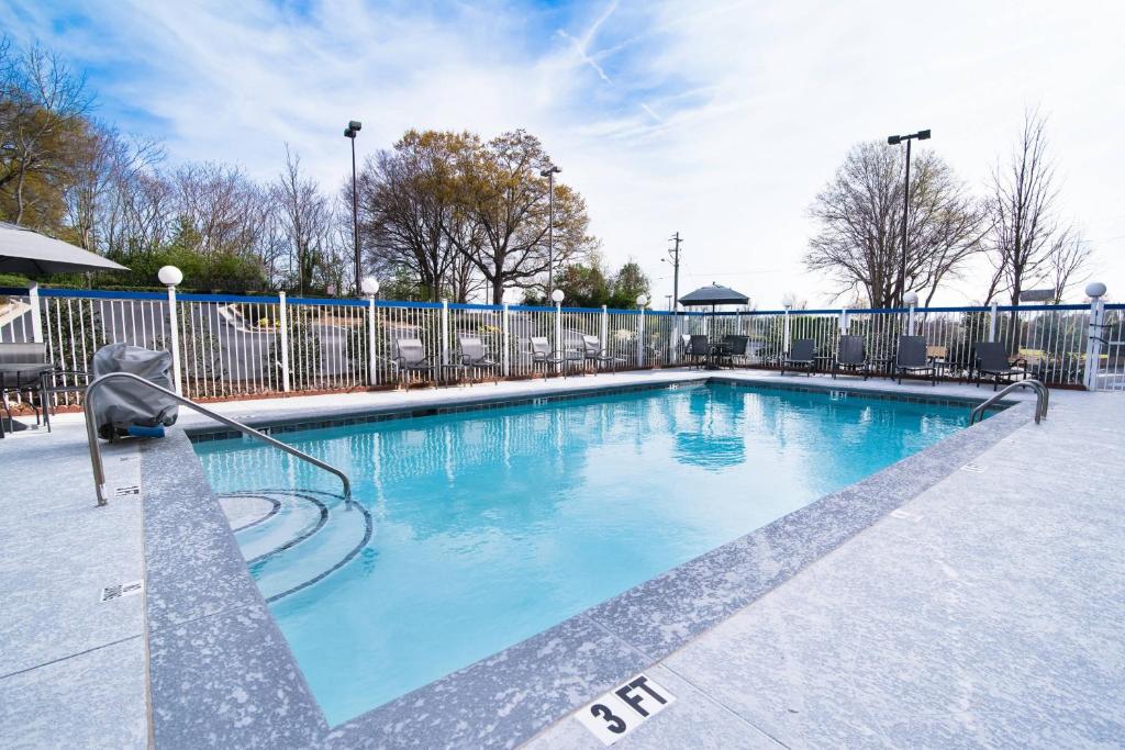 a swimming pool with blue water and a fence at Fairfield Inn & Suites Atlanta Airport North in Atlanta