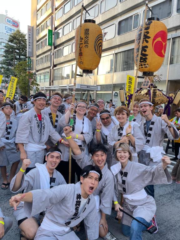 a group of people are posing for a picture at Sakura Hotel Ikebukuro in Tokyo