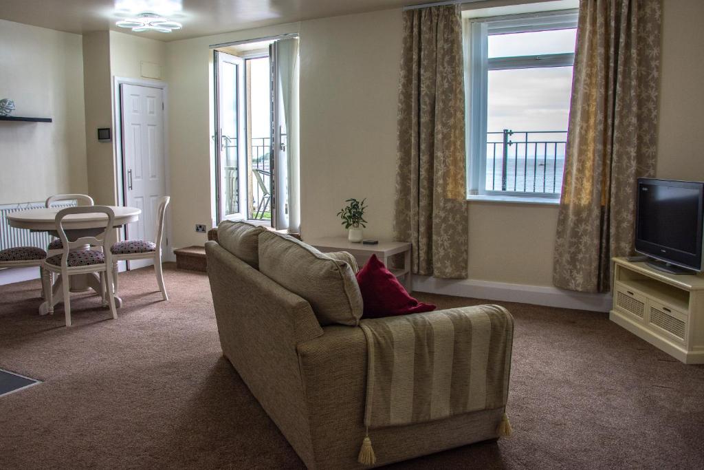 a living room with a couch and a television at Morecambe Central balcony with sea view in Morecambe