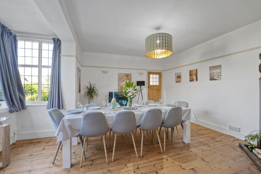 uma sala de jantar com uma mesa branca e cadeiras em Large family house in Worthing - 5 mins from beach em Worthing