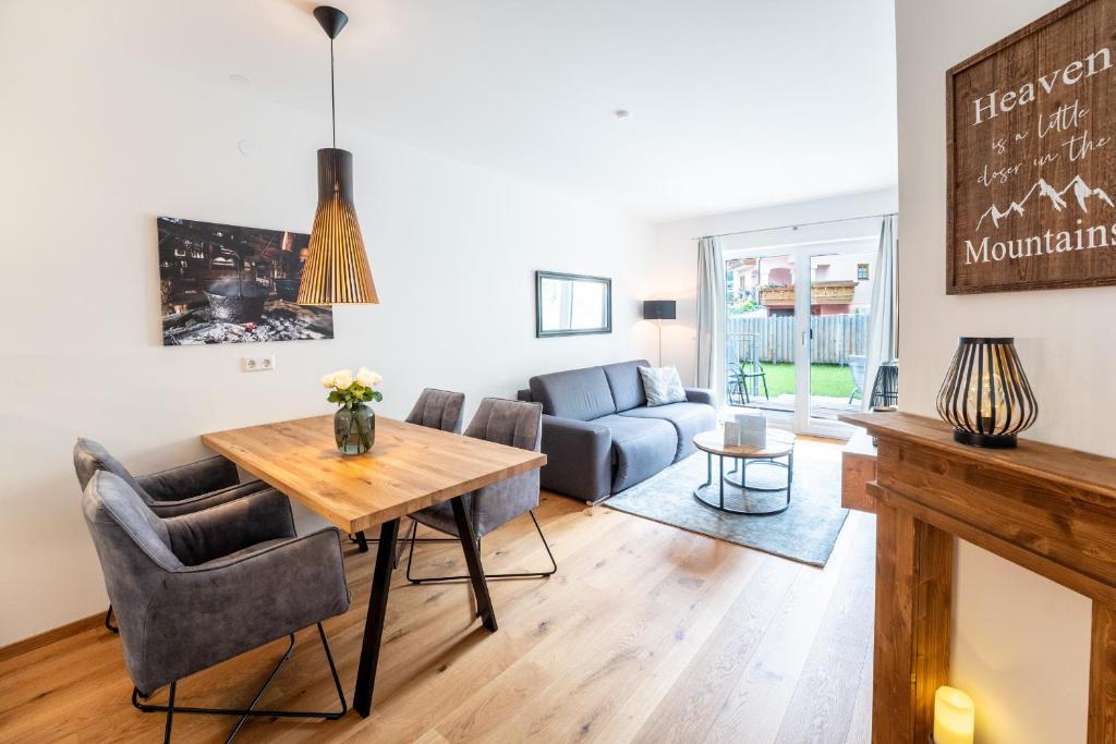 een woonkamer met een tafel en een bank bij Garten-Appartement Ski&Nature "Kesselspitze" in Mauterndorf