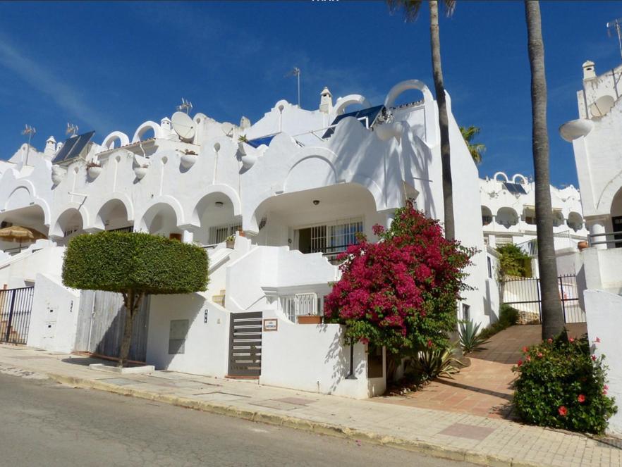 un edificio blanco con flores delante en Independent Apartment La reserve de Marbella, en Marbella