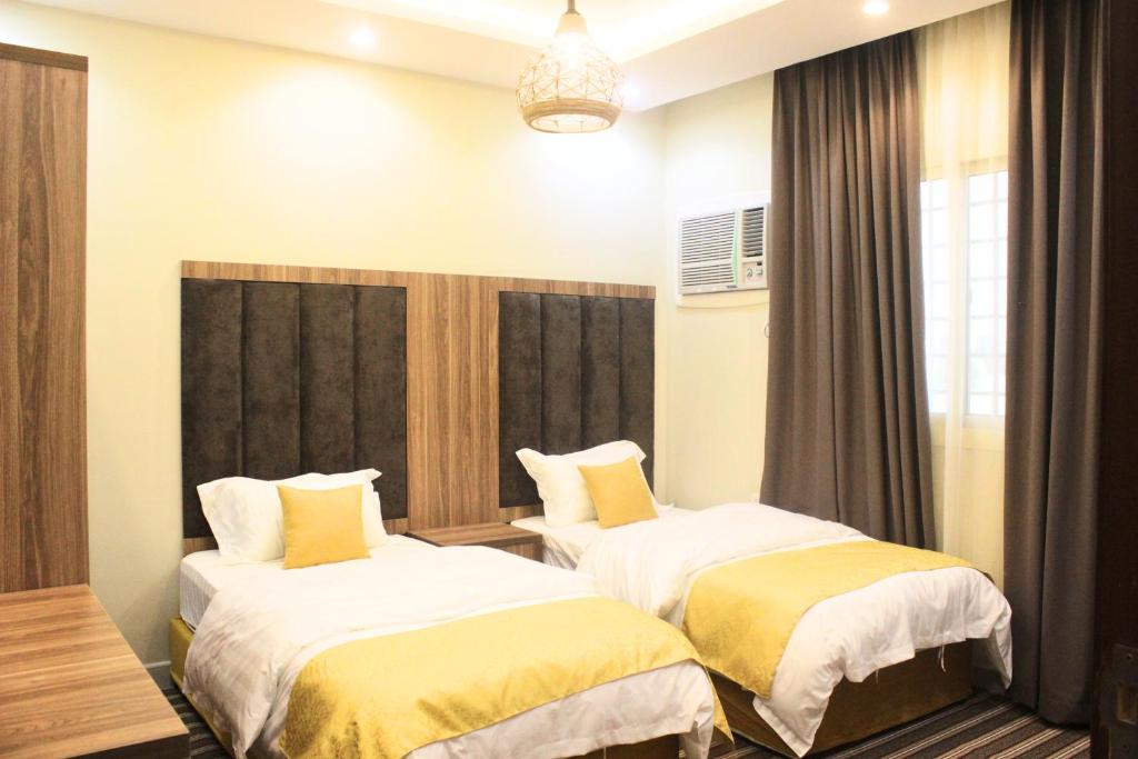 - une chambre avec 2 lits et des oreillers jaunes dans l'établissement شقق كيان الحجاز, à Djeddah