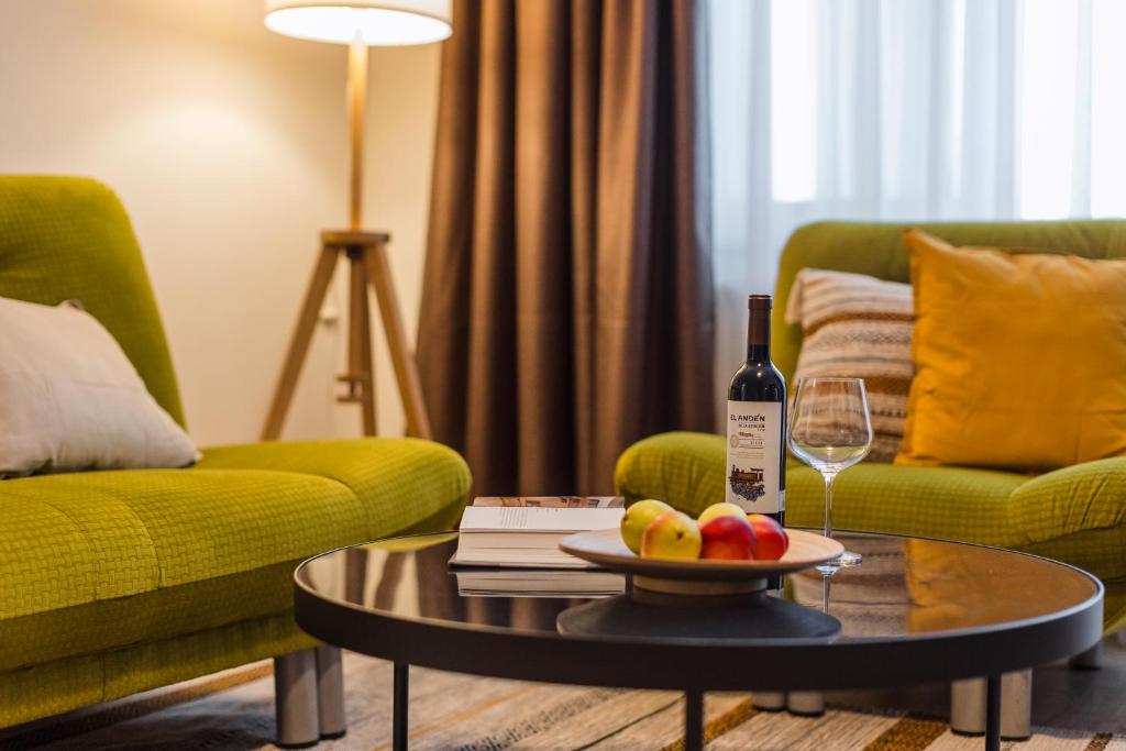 a living room with a bottle of wine and a table at Rox Central Apartments 4 in Timişoara