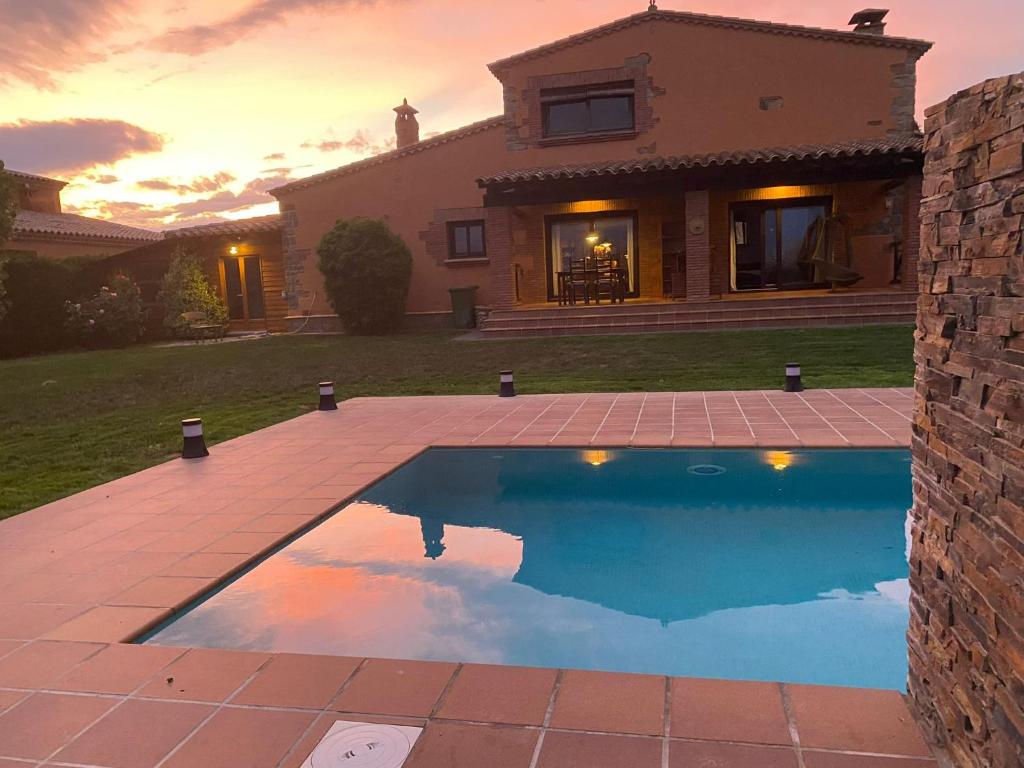 a house with a swimming pool in front of a house at Villa Sol Peralada Golf in Peralada