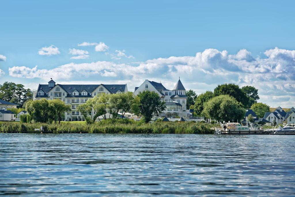 a group of houses on the shore of a body of water at Precise Resort Schwielowsee in Werder