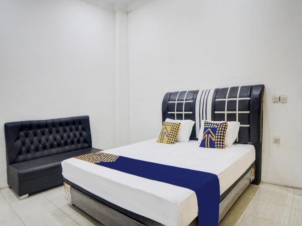 a bedroom with a bed and a couch at SPOT ON 92904 Penginapan Pakam in Lubukpakam