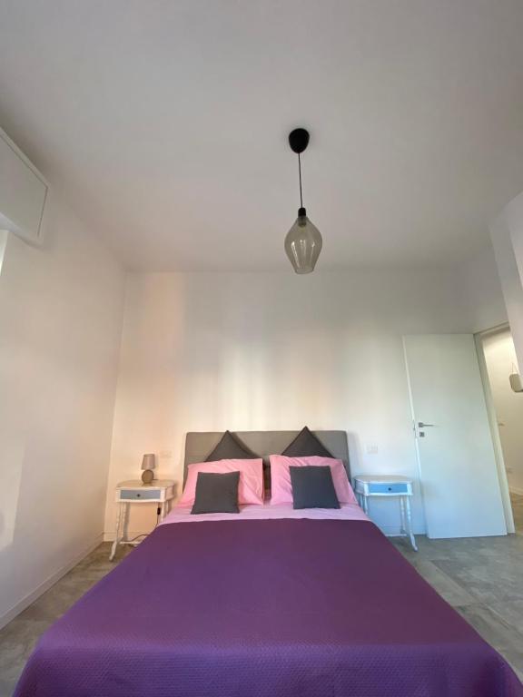 ein Schlafzimmer mit einem lila Bett mit rosa Kissen in der Unterkunft 'Na Chicca A Verona in Verona