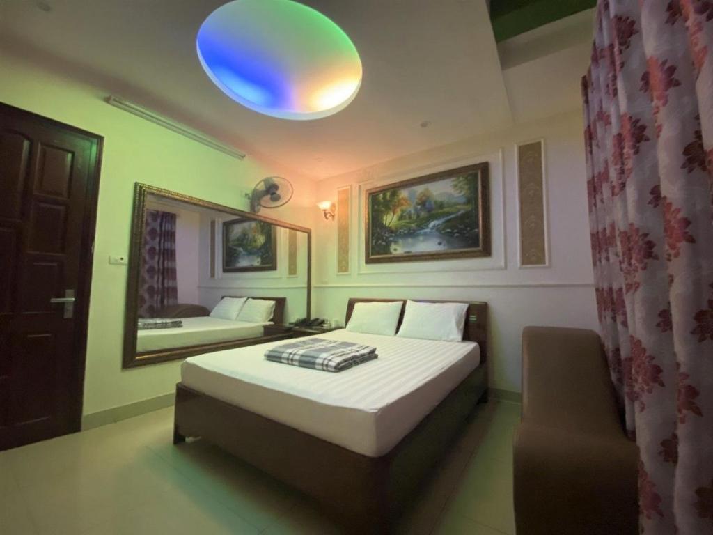 een slaapkamer met een bed, een spiegel en een stoel bij Jerry Hotel - Số 9 Ngõ 604 Trường Chinh - by Bay Hostel in Hanoi