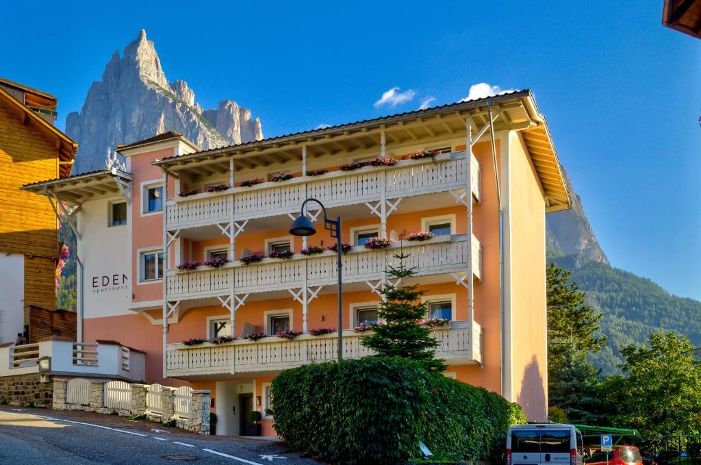a building with balconies and a mountain in the background at Eden Apartments in Siusi