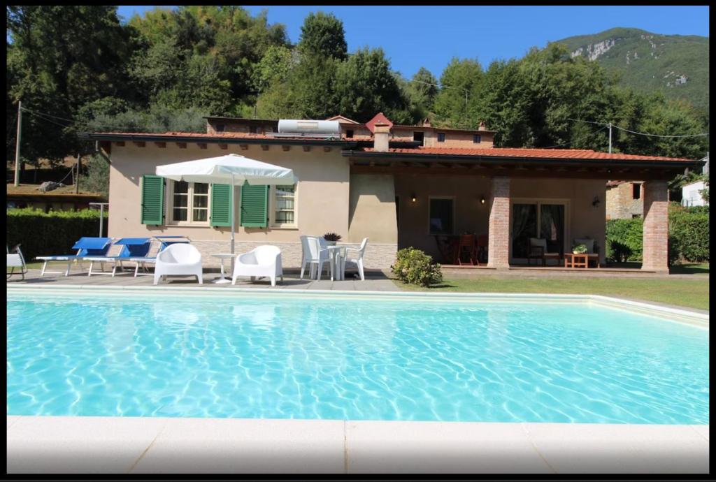 una casa con piscina delante de una casa en Casa Girasole, en Camaiore