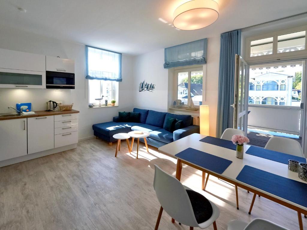 ein Wohnzimmer mit einem blauen Sofa und einem Tisch in der Unterkunft Villa Freya - Apt. 03 in Ostseebad Sellin