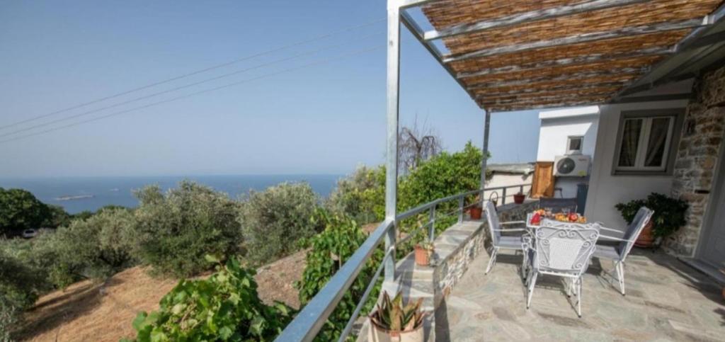 a balcony of a house with a table and chairs at Oneiro Cottage in Skopelos Town