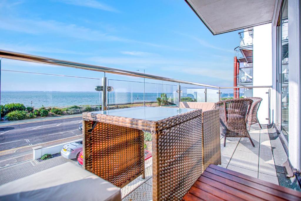 a balcony with a table and chairs and the ocean at Pass the Keys Stunning Sea Front Views in Westcliff-On-Sea