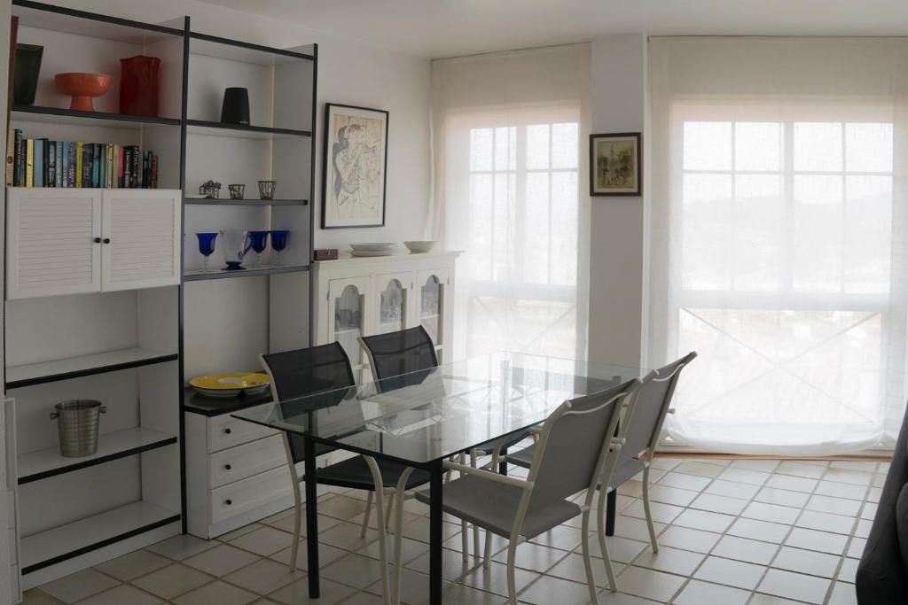 uma sala de jantar com uma mesa de vidro e cadeiras em Maravilloso apartamento con vistas al mar em Baiona