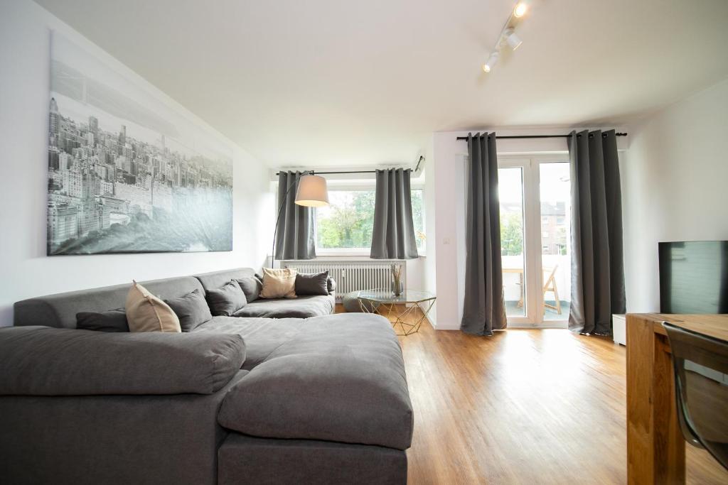 a living room with a couch and a television at Favorite Stays - Suite And More - Neuss in Neuss