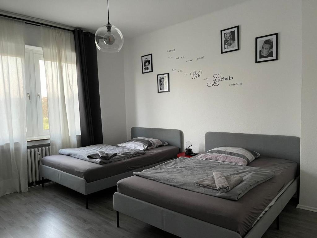 two beds in a bedroom with a wall with signatures at Ruhrpott Apartment Zentral Comfort in Herne