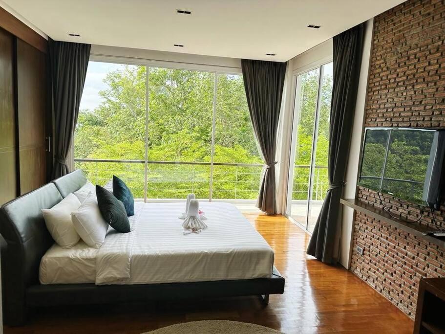 1 dormitorio con 1 cama grande y ventana grande en Luxury 2Bedroom Retreat Penthouse Kamala, en Phuket