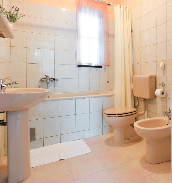 W łazience znajduje się toaleta, wanna i umywalka. w obiekcie Apartments Doda w mieście Zadar