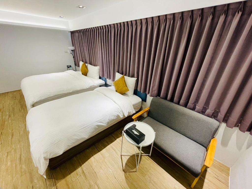 台北市にある森浩文旅のベッド2台とソファが備わるホテルルームです。
