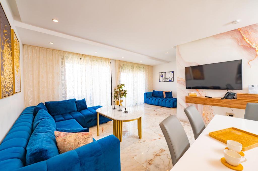 uma sala de estar com um sofá azul e uma televisão em Family Aparthotel em Casablanca