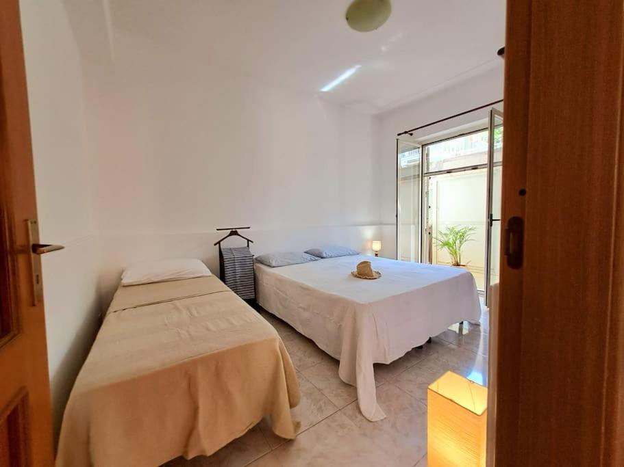 een slaapkamer met 2 bedden en een raam bij Ambra in Stazzo