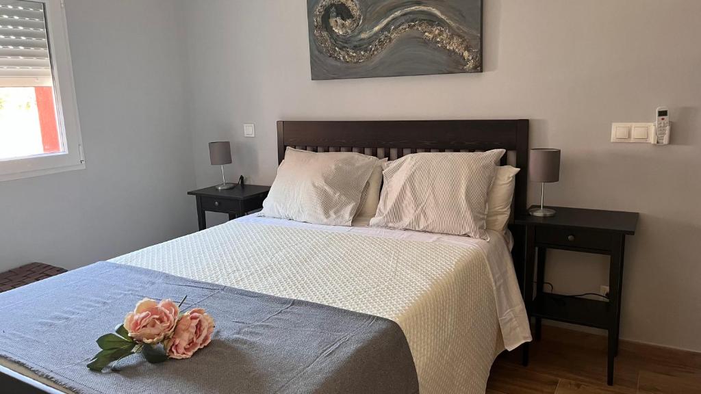 - une chambre dotée d'un lit avec deux roses dans l'établissement APARTAMENTO PRADERAS PANTANO SAN JUAN PRIMERA PLANTA, à Pelayos de la Presa