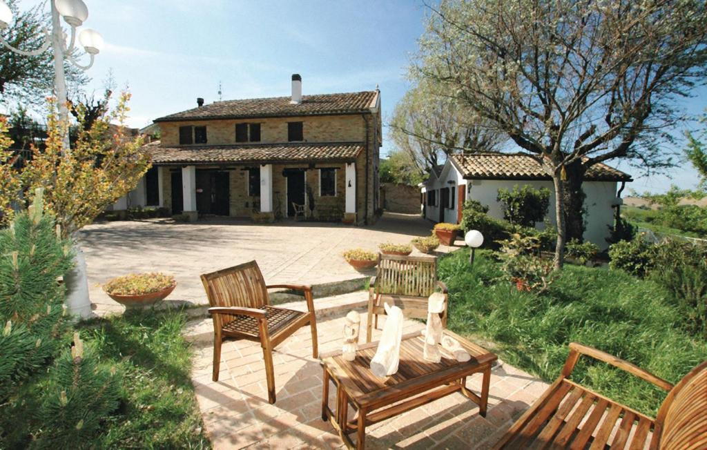 un patio con 2 sillas y una mesa frente a una casa en Casale Barbagianni, en Senigallia