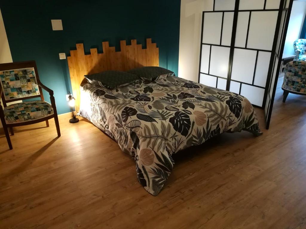 une chambre avec un lit et une chaise dans l'établissement Appart d'hôtes au naturel, à Saint-Amand-sur-Sèvre