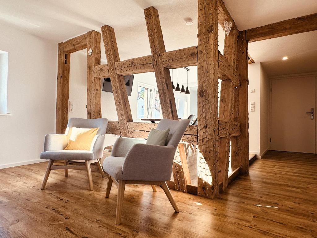 two chairs and a table in a room with wooden beams at Ferienhaus Lindenglück in Löffingen